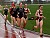 A Minnesota-Duluth runner leads Laura Edlund (r), Sarah Bernhardson (c) and Jill Fagerstrom (r) around a corner during the 5000.