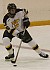 Freshman forward Mac Garceau plays the puck near center ice.