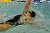 Backstroker looks at the end of the lane for support from teammates.