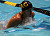 A swimmer breaches out of the water to make the most of each stroke.