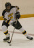 Freshman forward Mac Garceau plays the puck near center ice.