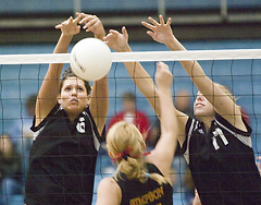 Becca Thompson (left) and Andrea Kron (right) reach for the block against Simpson