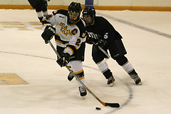 Junior captain Jay Phillips plays the puck near center ice.