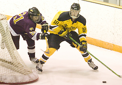 John Arundel, a junior, skates behind the net, looking to make a pass.