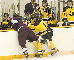 Eric Lindquist nearly sends a UM-Crookston player into the Gustavus bench.