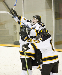 Mike Carr (l) and Josh Gaw (r) mob Kyle Rohlfs (c) following his goal.