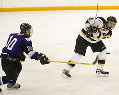 Jay Phillips shoots the puck in front of a Tommie.