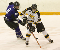 Mike Hosfield and a Tommie battle for the puck.