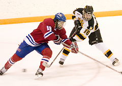 Steven Jensen pokes the puck away from Saint John's Tom Hartman.