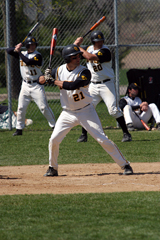 Ben Sherer stands at the plate while Wade Vrieze (l) and Shea Roehrkasse (r) take practice swings in the background.