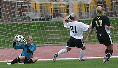 Julie Mahre makes a save as Alison Ditmer and a Nebraska Wesleyan player look on.