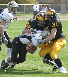 Adam Miron and Blake Theisen bring down a St. Olaf ball-carrier during last Saturday's game.