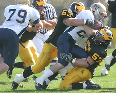 Nick David (53) and Taylor Beahrs (57) take down Bethel's Phil Porta, the league's leading rusher.