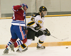 Joe Welch fights along the boards for the puck.