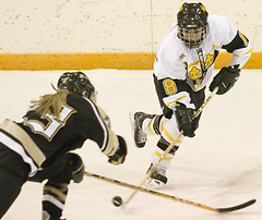 First year Melissa Mackley plays the puck past a St. Olaf defender.