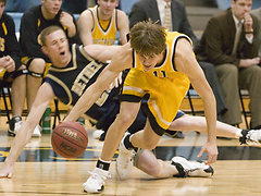 Trevor Wittwer drives past a Bethel defender in front of the Gustavus bench.