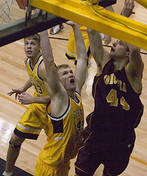Jay Stien contests a shot by Concordia's James Baldwin. Andrew Doble (33) looks to grab the rebound.