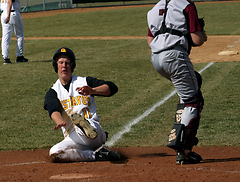 Freshman Spencer Campion slides into home plate behind the Augsburg catcher.