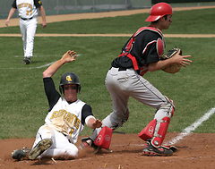 Tyler Kaus slides in to home plate ahead of a tag in a 9-3 win in game one.