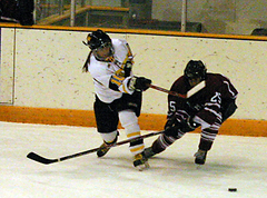 A Gustavus player passes around a Hamline defender.