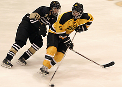  Spencer Campion of Gustavus skates past Bryan Osmundson of St. Olaf.