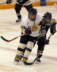Lynn Hillen looks for the puck against a St. Olaf defender.
