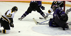 Patrick Dynan works to control the puck on his knees in front of the St. Thomas net. (Photo: Ryan Coleman, d3sports)