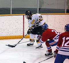Jamie Leathers carries the puck behind the Johnnies net.