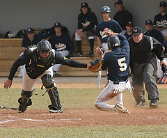 Catcher Shea Roehrkasse tags a Carleton runner out at the plate.