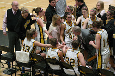 Coach Mickey Haller encourages her team in the huddle late in the game.