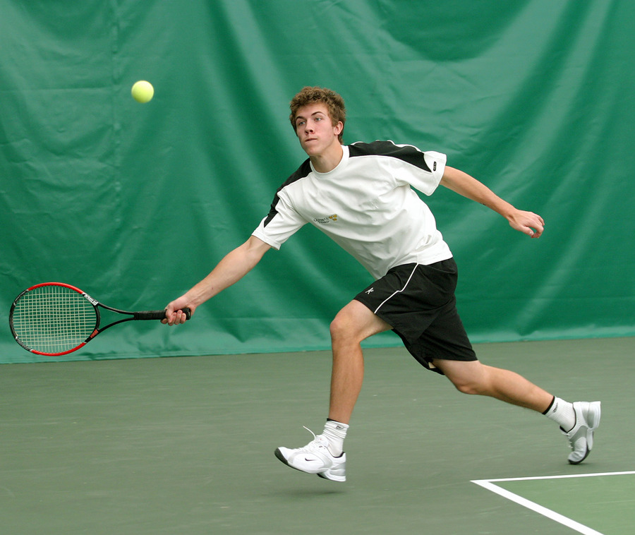 Freshman Andy Bryan stretches for a forehand return in the #3 doubles match.