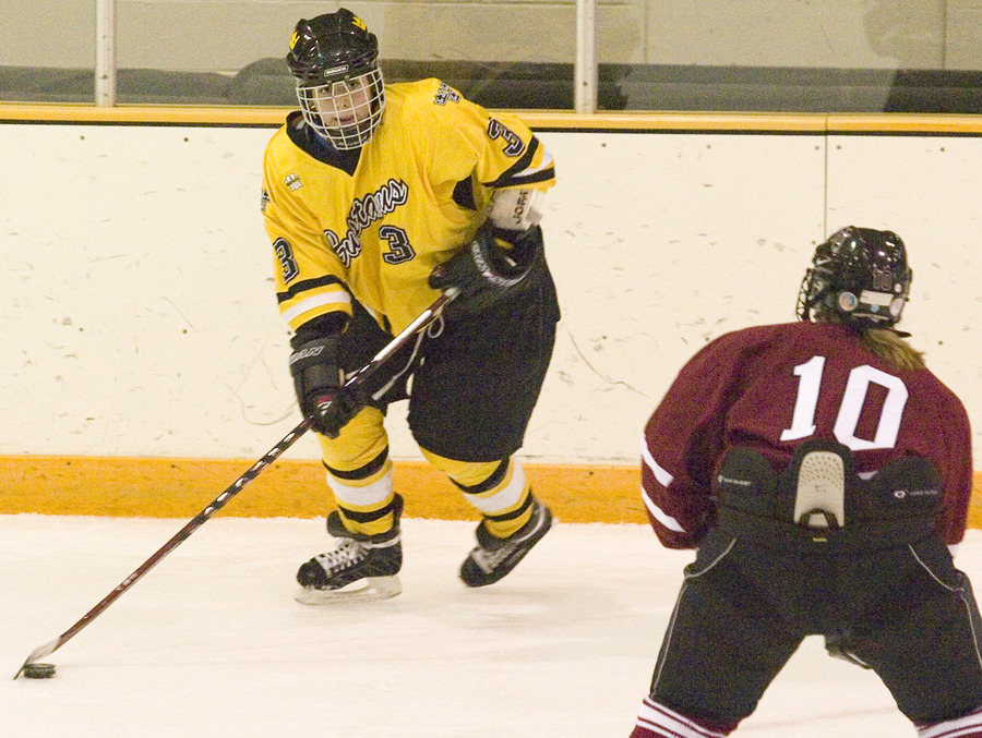 Stefanie Ubl controls the puck near the boards.