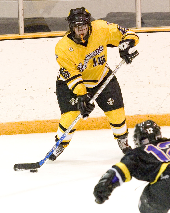 Sophomore Margaret Dorer plays the puck along the boards.