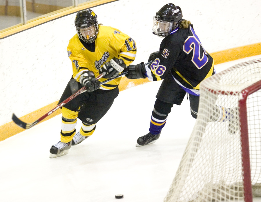 First-year Christine Wicker fights through the stick of Stevens Point’s Rachael Graves