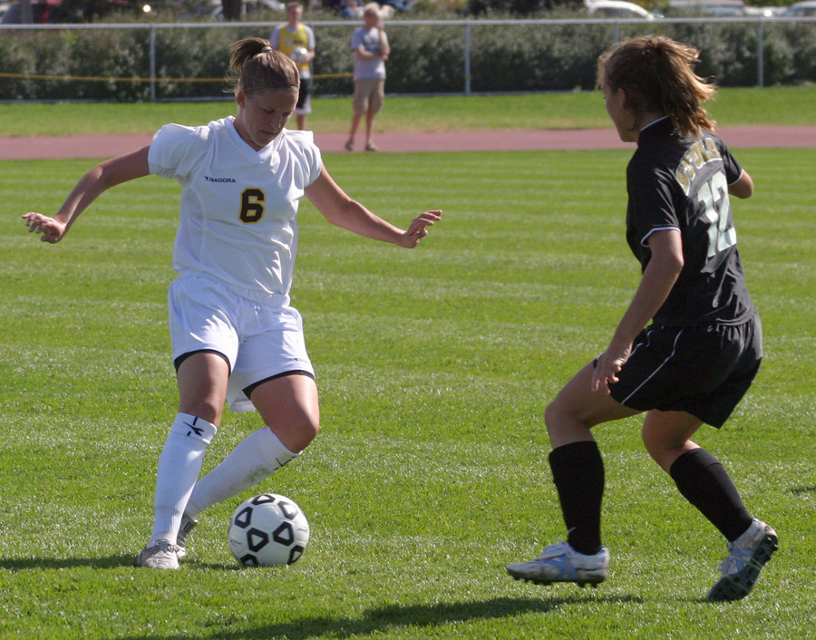 Senior Amy Larson plays the ball past a St. Olaf defender.