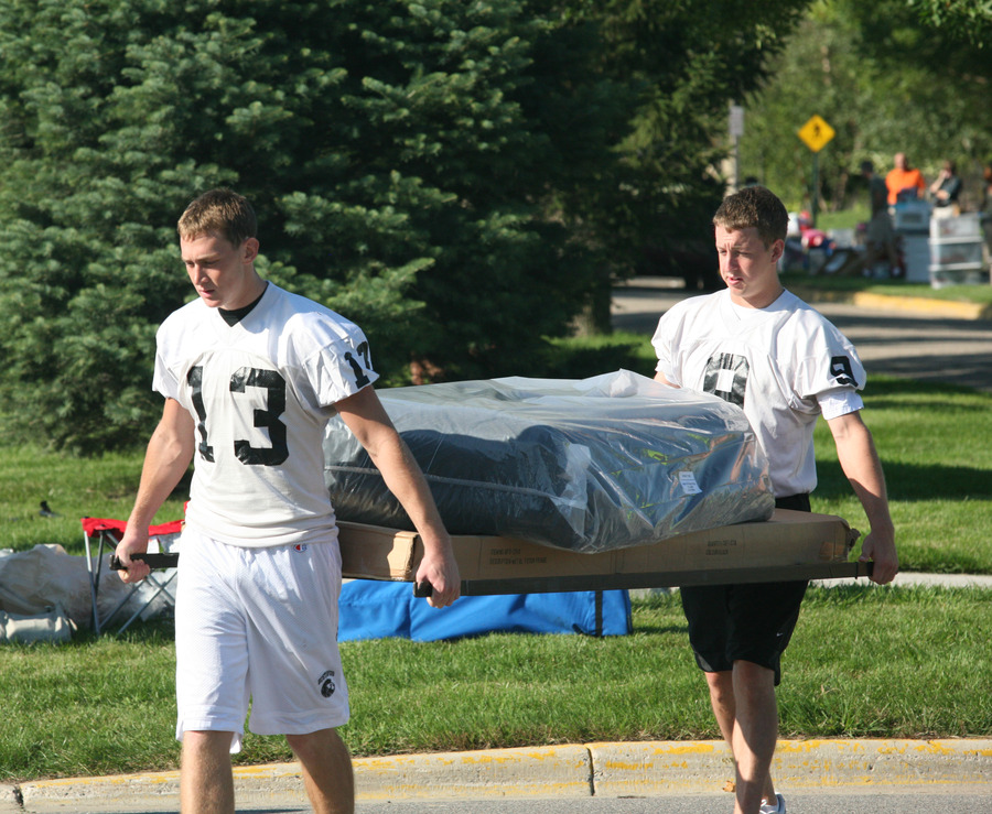 The Gustavus football team traditionally helps families of first-year students move in to the residence halls as a fundraiser.