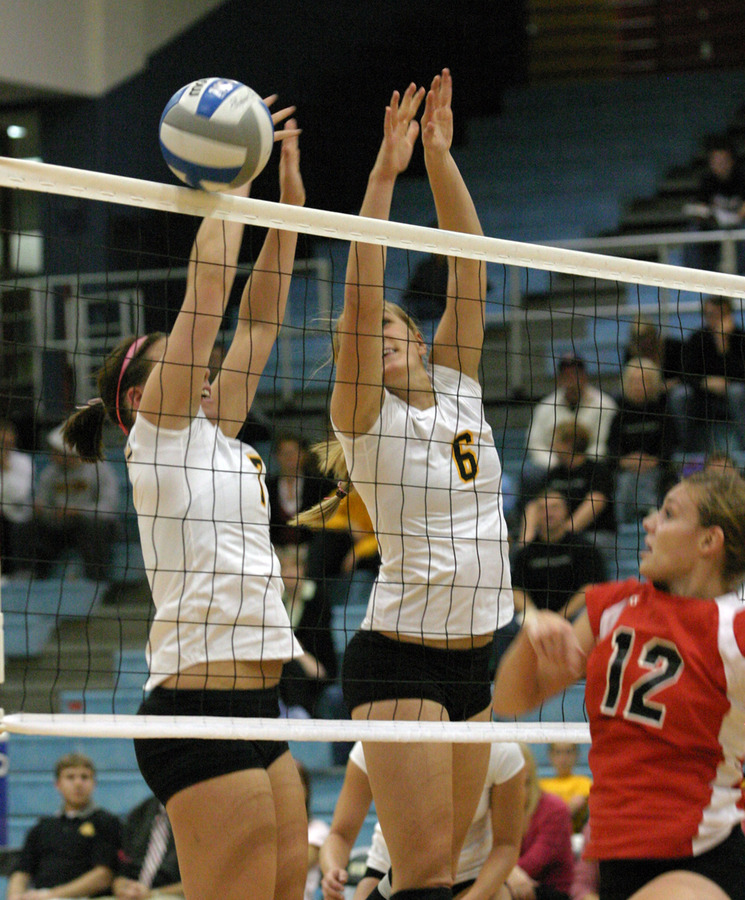 Bridget Burtzel and Meghan Gehring try to block an attack from Emma Jaynes.