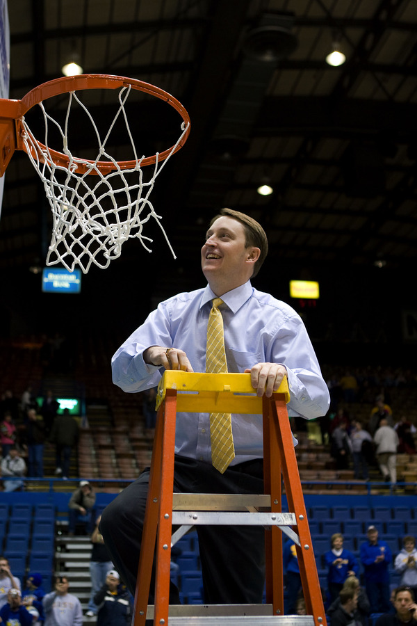 Aaron Johnston ‘96 cutting down the net after his team won the Summit League Tournament. (Photo courtesy of SDSU Athletics)