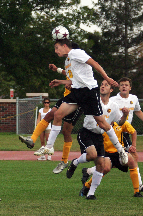 Bret VanderStreek heads a ball to a teammate in front of the goal.
