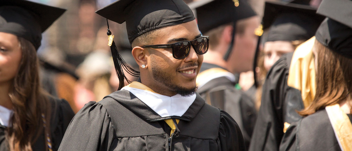 A Gustie in full cap and gown at graduation.