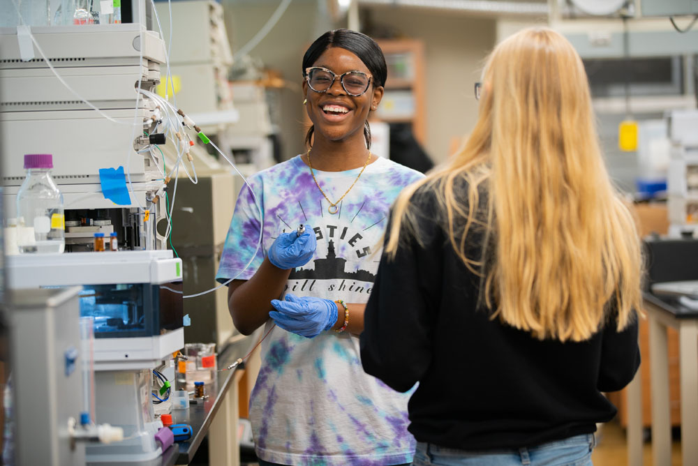 Female African American student laughing while working in a science laboratory