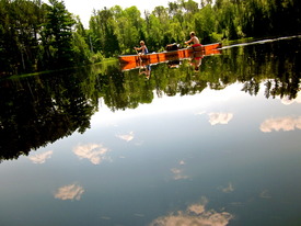 Students canoe on a pristine lake