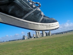 Forced perspective shot looks like a person in a tennis shoe stepping on a tiny Stonehenge