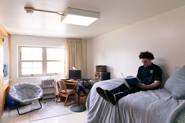 Student in residence hall room reading