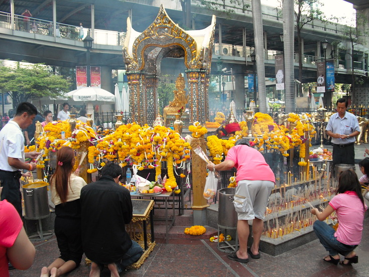 People adding flowers to a festival altar in Asia