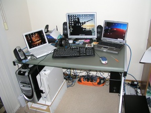The external monitors, laptops, keyboard, mouse, speakers, power strip, extra computer tower, and headphones would all be examples of After-Market products in this picture.