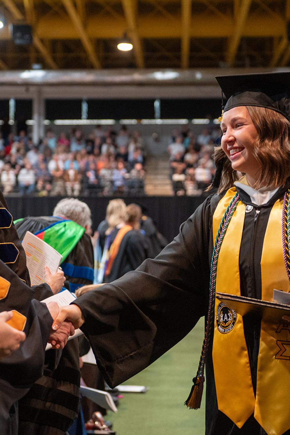 2026 graduate shaking hands with the faculty