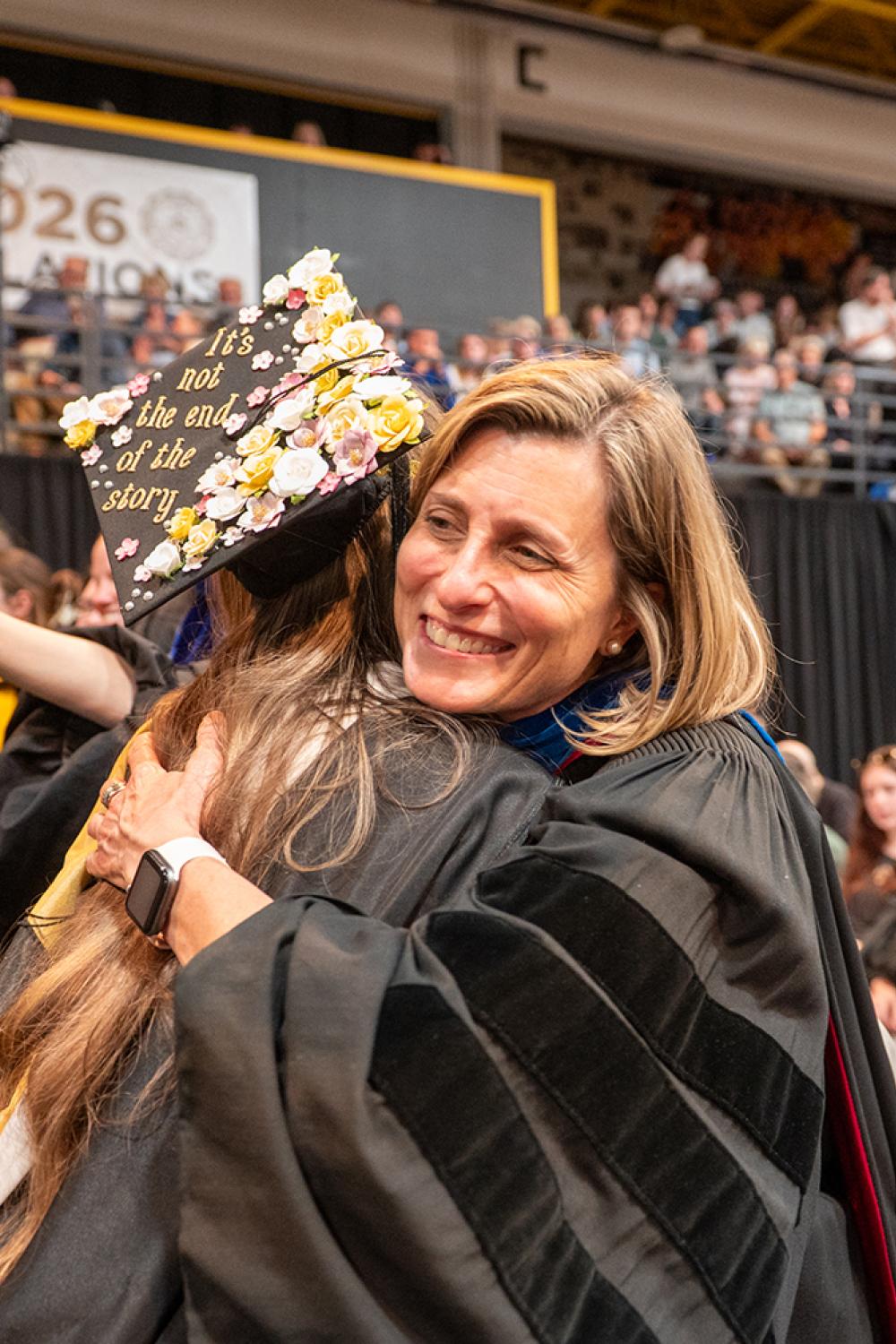 2026 student hugging faculty member at commencement
