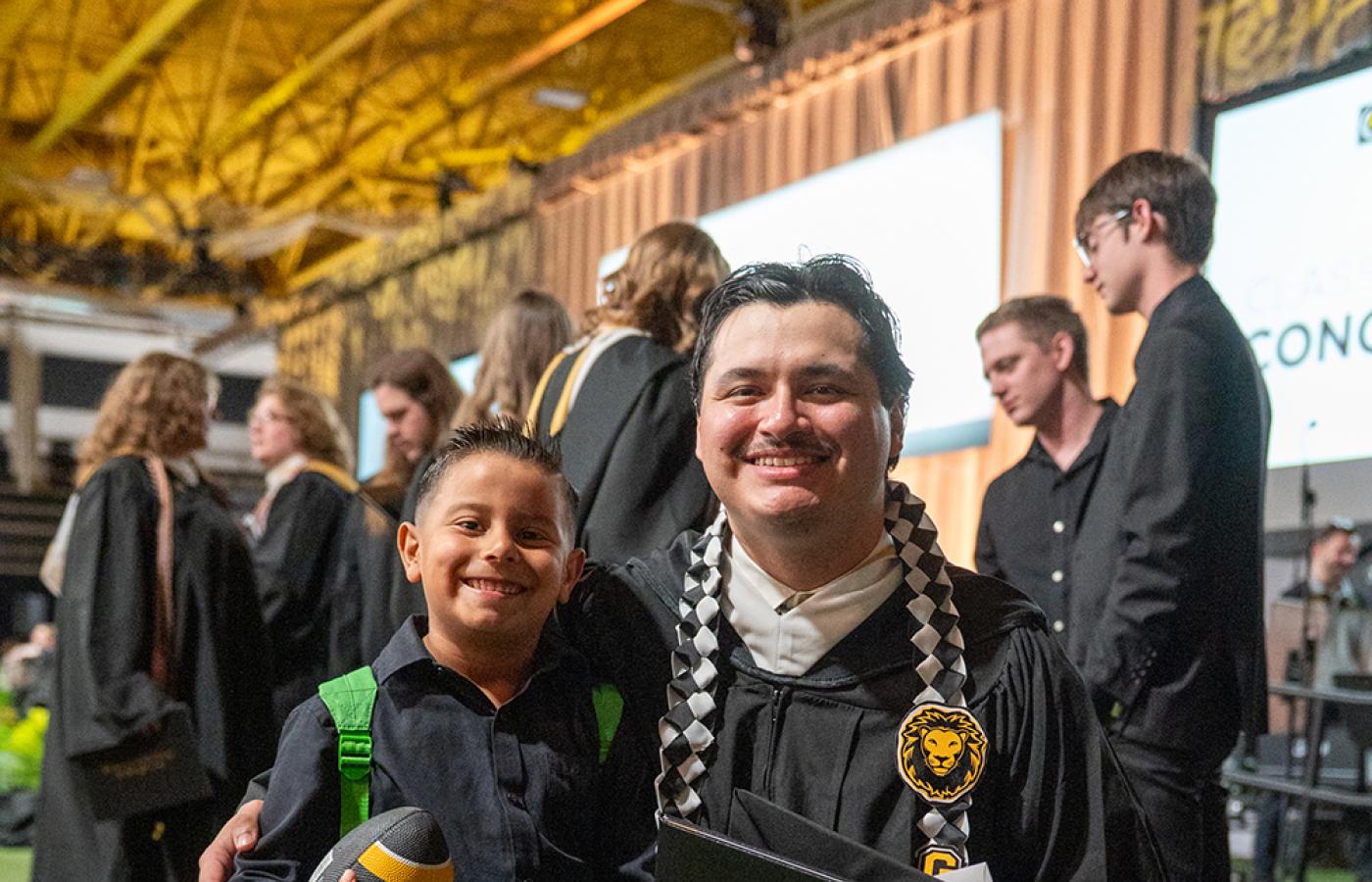 2026 grad with future Gustie holding football