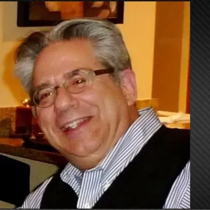 Portrait of Gregory Lawrence Kaster smiling indoors, with Gustavus Adolphus College branding
